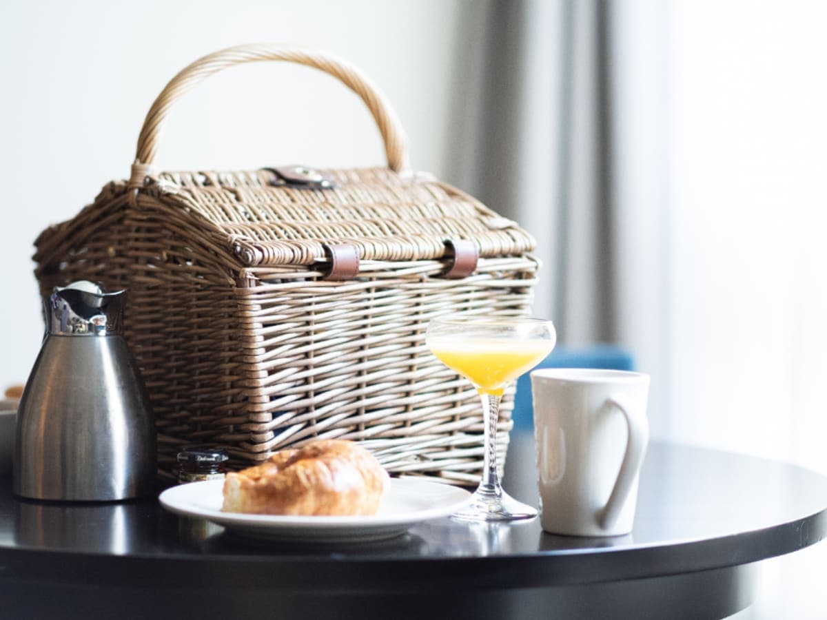 A breakfast hamper and a coffee pot on a table.