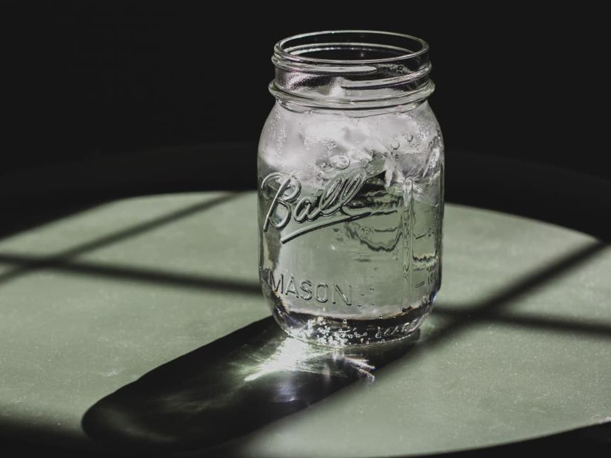 An empty glass jar casting a long shadow.