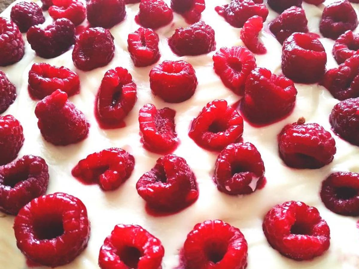 A cake covered edge to edge in fresh raspberries.